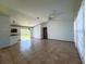 Bright, spacious living room featuring tiled floors, neutral walls, and a ceiling fan for added comfort at 12143 Du Barry Ave, Port Charlotte, FL 33981