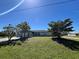 Charming single-story home with a well-maintained lawn and mature trees under a clear blue sky at 12143 Du Barry Ave, Port Charlotte, FL 33981