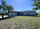 Charming single-story home with a well-maintained lawn and lush trees on a sunny day at 12143 Du Barry Ave, Port Charlotte, FL 33981