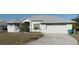 Beautiful home showcasing a spacious driveway, lush lawn, and charming curb appeal at 17220 Horizon Ln, Port Charlotte, FL 33948