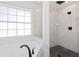Bright bathroom with a tiled shower, glass partition and soaking tub next to large window at 193 Beeney Se Rd, Port Charlotte, FL 33952