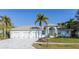 Charming single Gathering home featuring a three car garage, well manicured lawn and front yard palm trees at 193 Beeney Se Rd, Port Charlotte, FL 33952