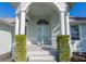 Elegant front entrance features double doors, columns, and manicured greenery for an inviting curb appeal at 193 Beeney Se Rd, Port Charlotte, FL 33952