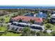 Beautiful aerial view of condo complex with red tile roof, lake, fountains, and waterfront views at 23465 Harborview Rd # 1006, Punta Gorda, FL 33980
