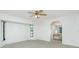 Spacious bedroom with plush carpet, ceiling fan, and bright natural lighting at 164 Chelsea Nw Ct, Port Charlotte, FL 33952