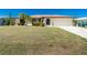 Inviting single-Gathering home with a green lawn, mature landscaping, and attached garage at 164 Chelsea Nw Ct, Port Charlotte, FL 33952