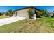 Well-maintained home with a clean exterior, attached two-car garage, and a neatly landscaped front yard with mature plantings at 164 Chelsea Nw Ct, Port Charlotte, FL 33952