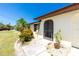 Charming home entrance featuring mature landscaping and a walkway leading to the front door, perfect for welcoming guests at 164 Chelsea Nw Ct, Port Charlotte, FL 33952