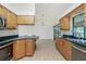 Bright kitchen with stainless steel appliances, natural wood cabinets, and tile floors at 164 Chelsea Nw Ct, Port Charlotte, FL 33952