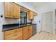 Cozy kitchen featuring wood cabinets, stainless steel dishwasher, and window views at 164 Chelsea Nw Ct, Port Charlotte, FL 33952
