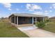Charming home featuring a screened porch, covered entry, and a well-manicured lawn at 30087 Alder Rd, Punta Gorda, FL 33982