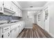 Well-lit kitchen boasts wood floors, white cabinets, and decorative backsplash at 30087 Alder Rd, Punta Gorda, FL 33982