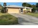 Charming single-story home featuring an attached garage, screen front door and mature landscaping at 4363 Sansedro St, Port Charlotte, FL 33948