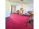 Expansive living room with red carpet, ceiling fan, and ample natural light at 4363 Sansedro St, Port Charlotte, FL 33948