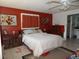 A well-lit bedroom with red walls, white bedding and ceiling fan at 4363 Sansedro St, Port Charlotte, FL 33948