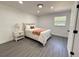 Cozy bedroom with new floors, side table, a window overlooking backyard, and a queen size bed at 1100 Belkton Ave, Port Charlotte, FL 33948