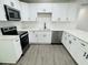 Modern kitchen with white cabinetry, stainless steel appliances and hard surface counters at 1100 Belkton Ave, Port Charlotte, FL 33948
