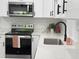 Bright kitchen features stainless steel appliances, white cabinets, black hardware, and white countertops at 1100 Belkton Ave, Port Charlotte, FL 33948