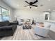 Bright living room adjacent to kitchen features a ceiling fan, recessed lighting, and hard surface flooring at 1100 Belkton Ave, Port Charlotte, FL 33948