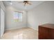 Well-lit bedroom with a ceiling fan, blind-covered window, and tiled floor at 17557 Ohara Dr, Port Charlotte, FL 33948