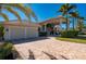 Charming home featuring an attached two-car garage and a spacious paver driveway, creating a welcoming entrance at 17557 Ohara Dr, Port Charlotte, FL 33948