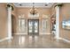 Grand foyer with soaring ceilings, decorative columns, and elegant chandelier, offering a luxurious entrance at 17557 Ohara Dr, Port Charlotte, FL 33948