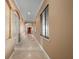 Long hallway with travertine flooring, decorative trim, and natural light at 17557 Ohara Dr, Port Charlotte, FL 33948