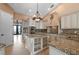 Gourmet kitchen featuring custom cabinetry, granite countertops, a center island, and stainless steel appliances at 17557 Ohara Dr, Port Charlotte, FL 33948