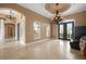 Elegant living room features travertine floors, decorative windows, and a chandelier at 17557 Ohara Dr, Port Charlotte, FL 33948