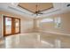 Living room features stone tile floors, tray ceiling, ceiling fan and french doors to exterior at 17557 Ohara Dr, Port Charlotte, FL 33948