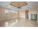 Living room features stone tile floors, tray ceiling, ceiling fan and three windows at 17557 Ohara Dr, Port Charlotte, FL 33948