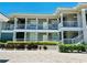 Coastal condo building featuring well-maintained landscaping and multiple levels with balconies at 3311 Wood Thrush Dr # 111, Punta Gorda, FL 33950