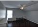 This bedroom has neutral walls, wood floors, a ceiling fan, and large windows at 5275 Layton Dr, Venice, FL 34293