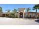Inviting clubhouse with an arched entrance, palm trees, and ample parking at 5275 Layton Dr, Venice, FL 34293
