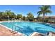 Community pool with crystal-clear water, lounge chairs, and lush palm trees, a perfect place to relax and unwind at 5275 Layton Dr, Venice, FL 34293
