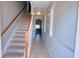 Bright hallway with tiled floors leading to a staircase and a glimpse of the living area at 5275 Layton Dr, Venice, FL 34293
