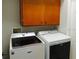 This laundry room features a washer, dryer, and cabinet storage space above at 5275 Layton Dr, Venice, FL 34293