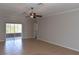 Spacious living room with neutral walls, tile floors, ceiling fan and sliding glass doors to the patio at 5275 Layton Dr, Venice, FL 34293