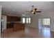 Open-concept living space with kitchen island, ceiling fans and sliding glass doors to the patio at 5275 Layton Dr, Venice, FL 34293