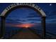 Night view of the iconic archway entrance of the Venice Fishing Pier at sunset with a crescent moon at 5275 Layton Dr, Venice, FL 34293