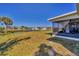 Backyard features a wide expanse of grass and views of the screened-in lanai at 102 Annapolis Ln, Rotonda West, FL 33947