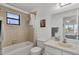 Bathroom with beige tile, a shower-tub combo, and a view into the bedroom in the mirror at 102 Annapolis Ln, Rotonda West, FL 33947