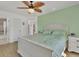 Bright bedroom features a wooden ceiling fan, mint accent wall and white wood flooring at 102 Annapolis Ln, Rotonda West, FL 33947