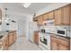 Bright kitchen featuring granite counters, white appliances, and marble look flooring at 102 Annapolis Ln, Rotonda West, FL 33947