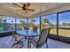Enclosed lanai with ceiling fan features a glass-top table and views of the waterway at 102 Annapolis Ln, Rotonda West, FL 33947