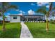 Picture-perfect lawn with a walkway leads to the home's screened-in lanai with a pool and patio at 1380 Willet Ct, Punta Gorda, FL 33950