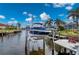 View of boat lift with blue boat, located on canal with dock in backyard at 1380 Willet Ct, Punta Gorda, FL 33950
