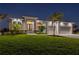 Charming home exterior at night, featuring manicured lawn and a well-lit entryway at 1380 Willet Ct, Punta Gorda, FL 33950