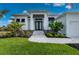 Stunning front exterior showcasing a modern home with lush landscaping and a paver walkway leading to the entrance at 1380 Willet Ct, Punta Gorda, FL 33950