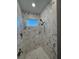 Contemporary shower featuring white-tiled walls with black accents, window, and showerhead at 16305 Branco Dr, Punta Gorda, FL 33955